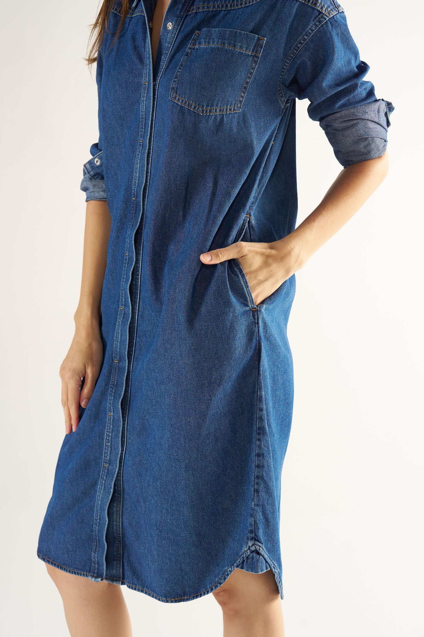 Blue denim dress worn by a person on a white background