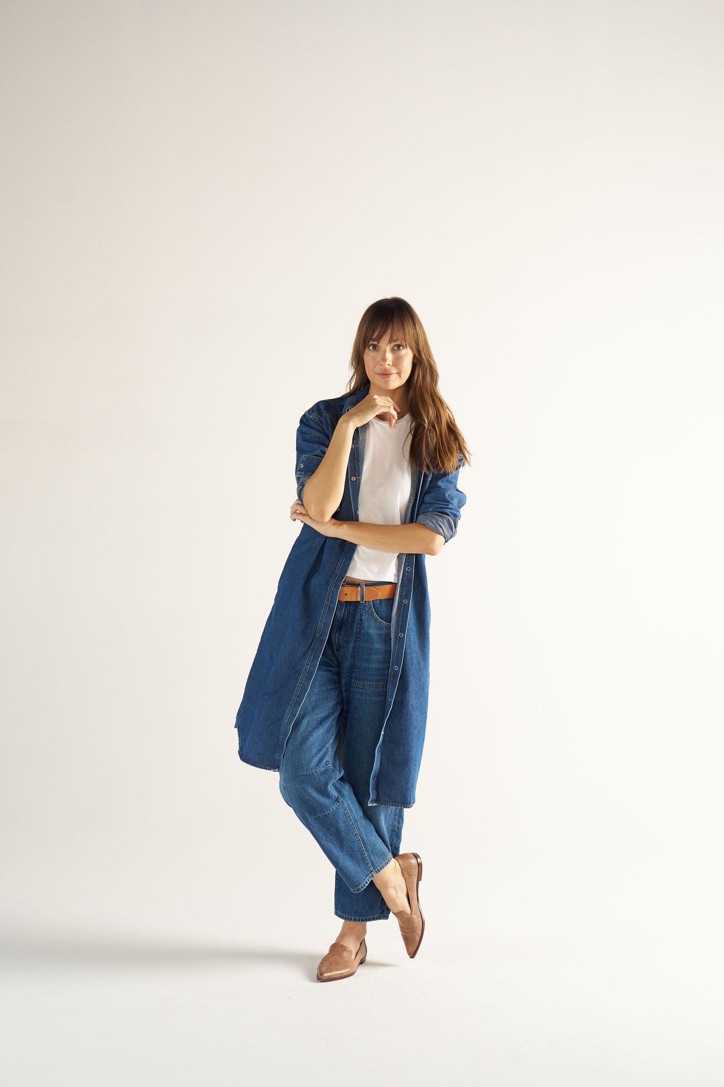 Woman wearing a blue denim outfit on a white background