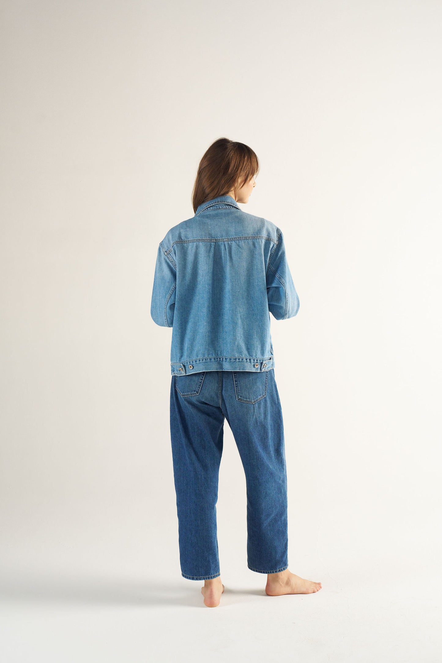 Woman wearing a blue denim outfit on a white background