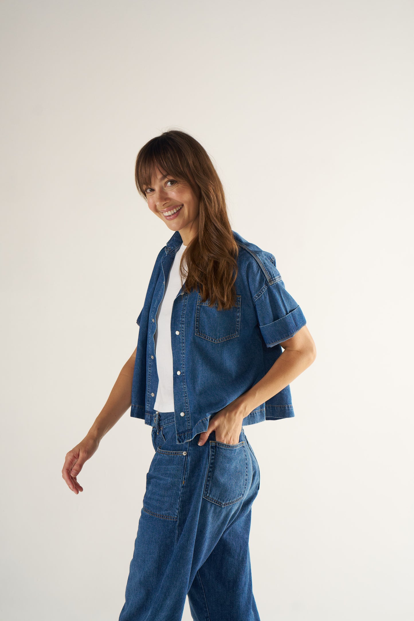 Woman wearing a denim outfit on a plain background