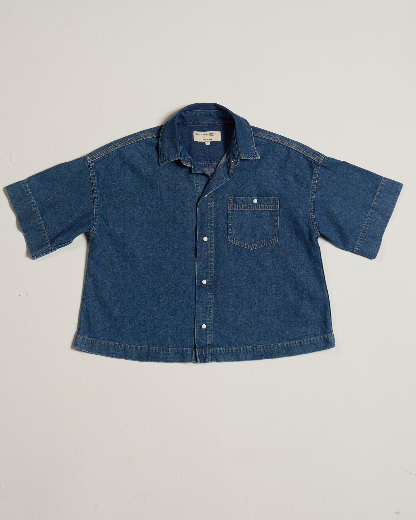 Blue denim shirt on a light gray background