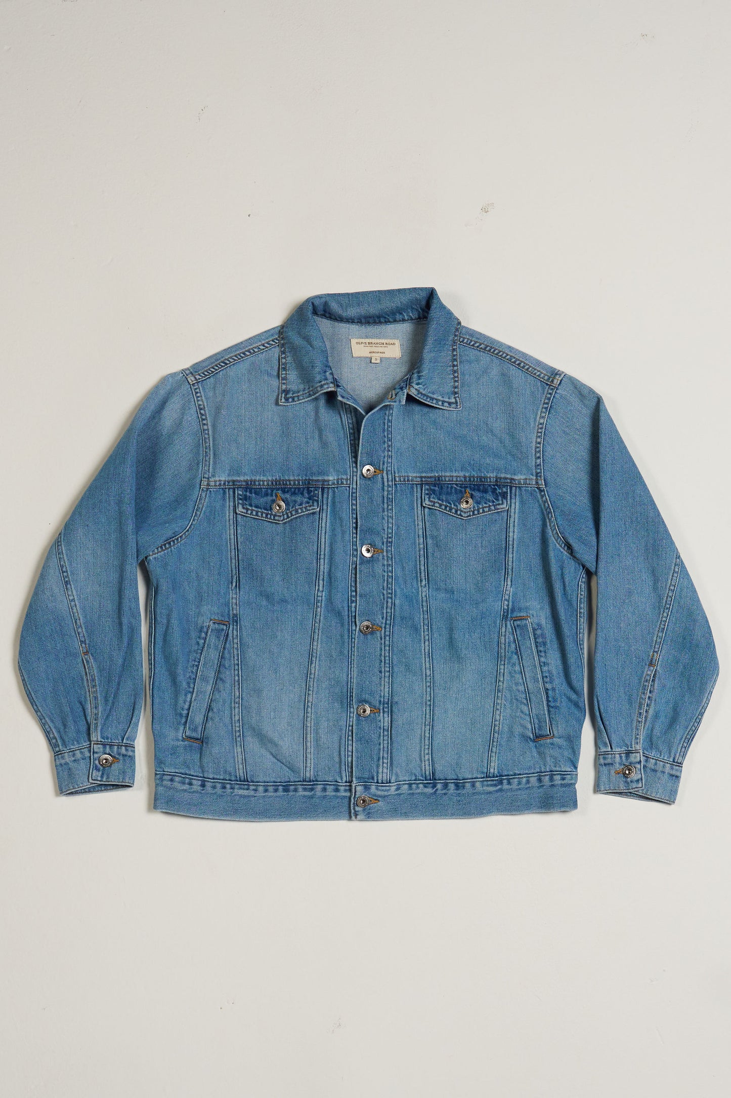 Blue denim jacket on a light gray background