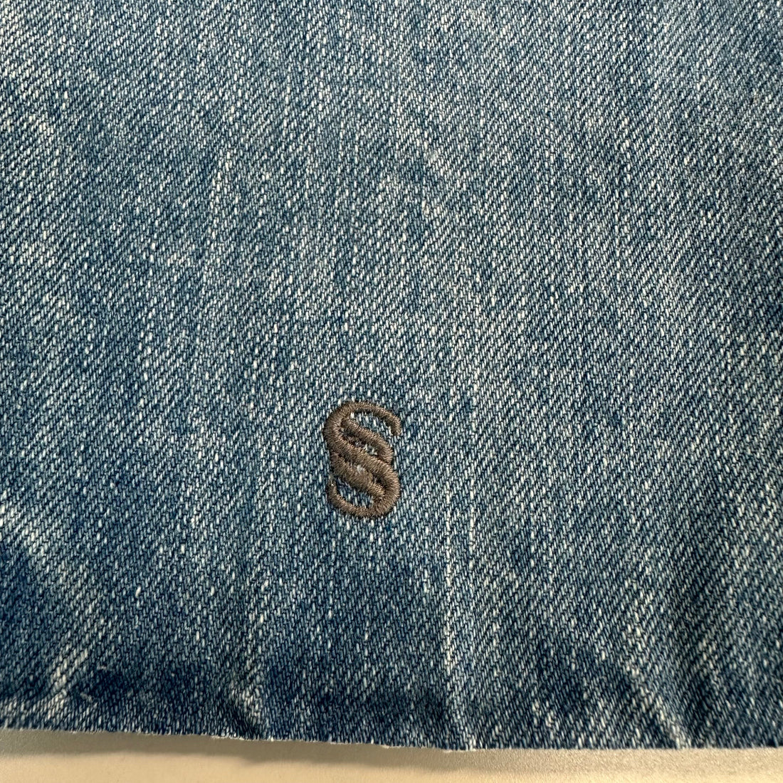 Denim swatch with brown logo