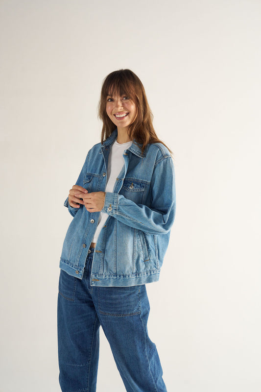 Woman wearing a denim jacket and jeans on a white background