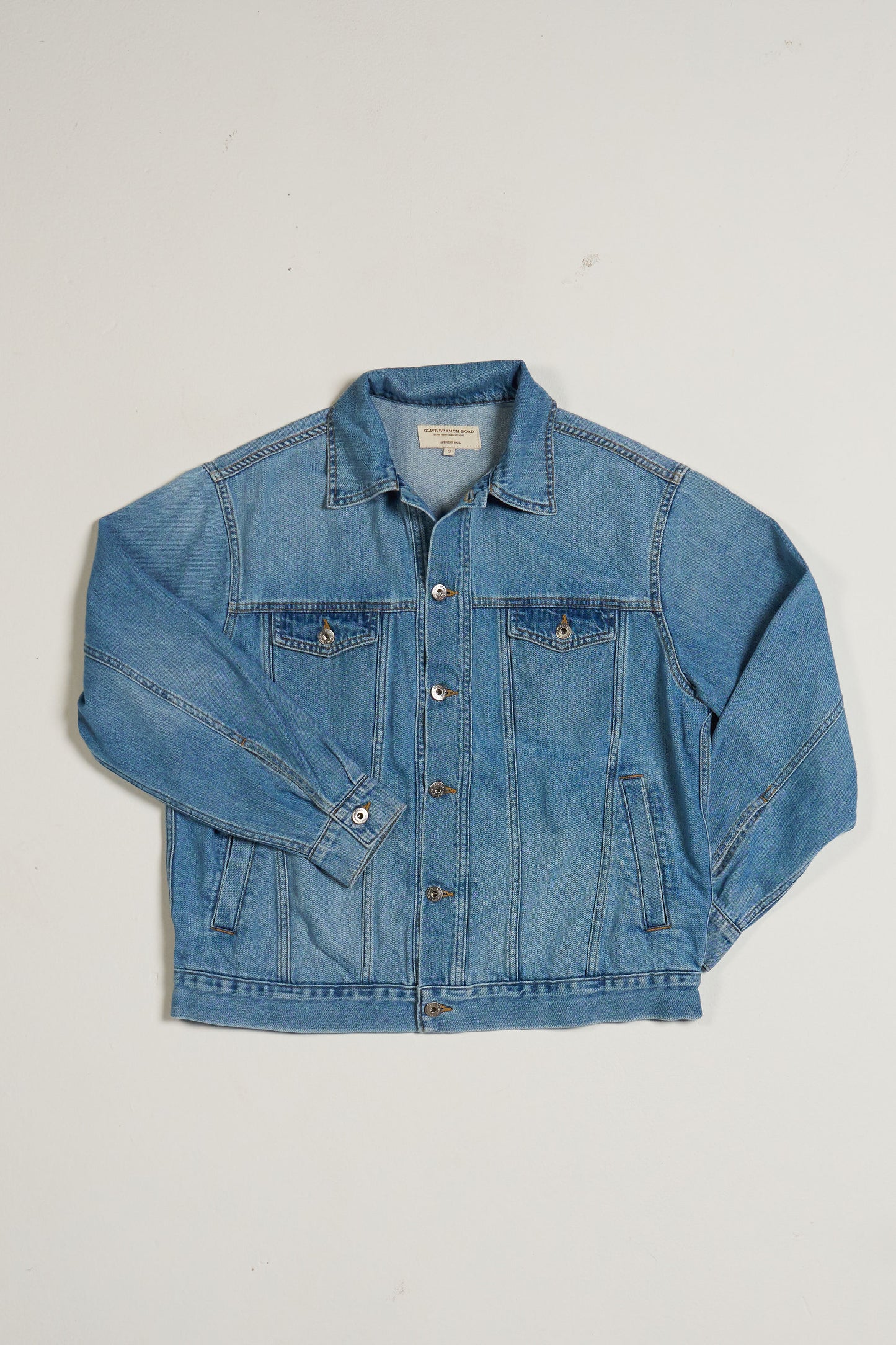 Blue denim jacket on a light gray background